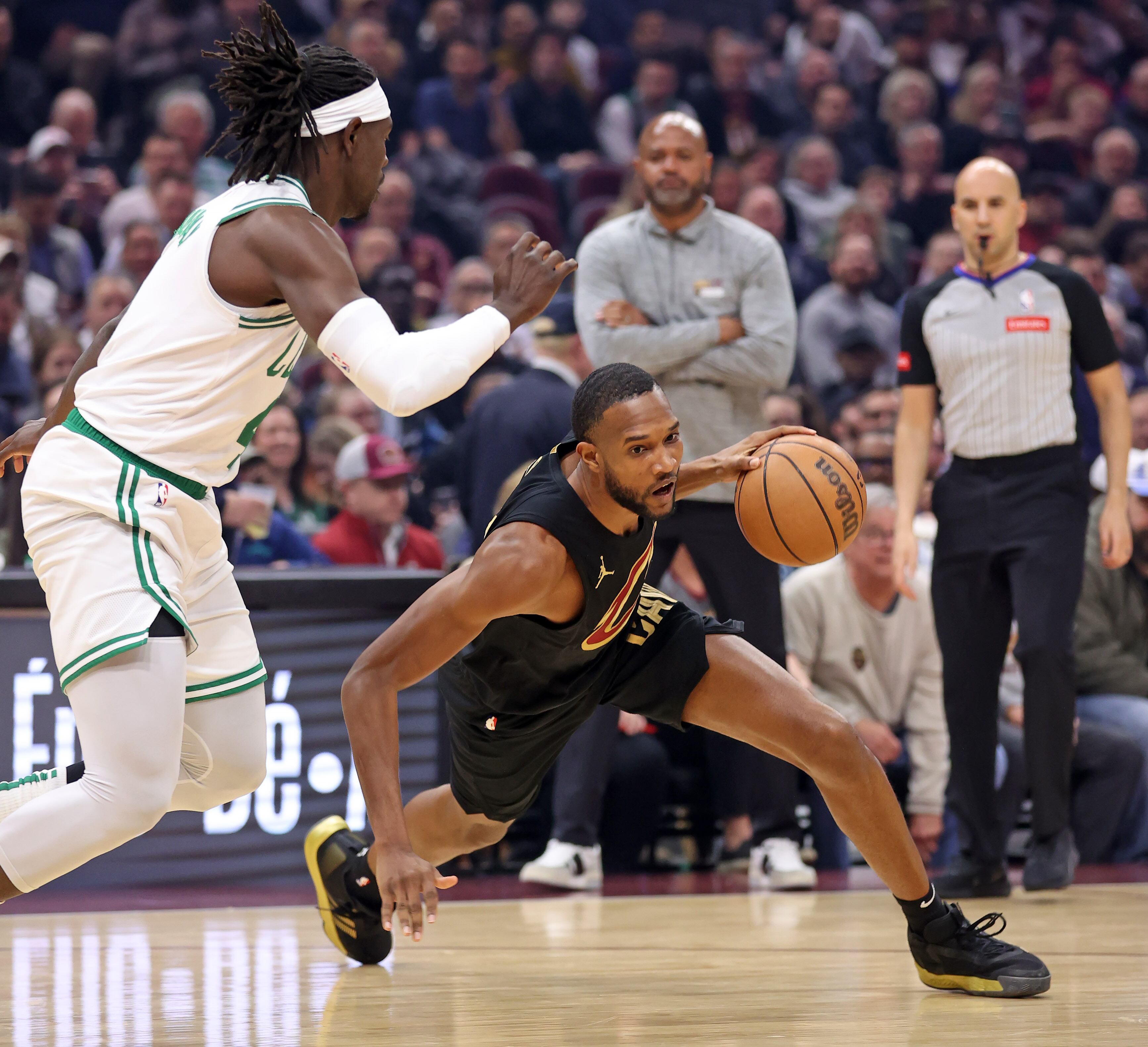 Cleveland Cavaliers forward Evan Mobley slips and falls as Boston Celtics guard Jrue Holiday defends in the first half of play. 