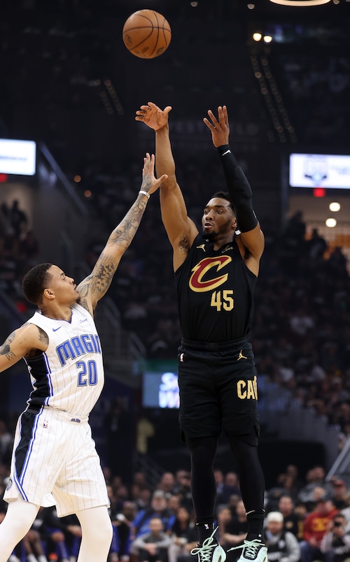 Cleveland Cavaliers guard Donovan Mitchell shoots a three against Orlando Magic guard Markelle Fultz in the first half of play.